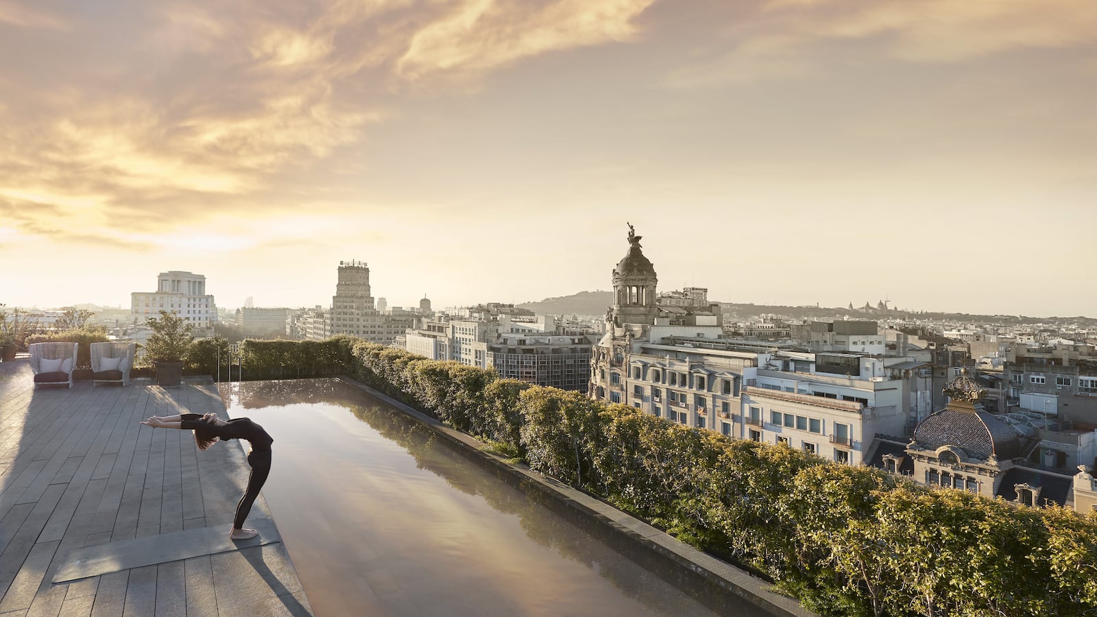Woman doing yoga at rooftop pool in uxury-spa-Mandarin Oriental, Barcelona  